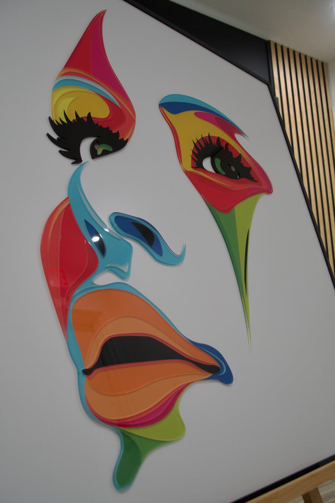 Abstract acrylic wall art of a woman's face in vibrant colors, designed to add elegance and bold style to modern interiors.